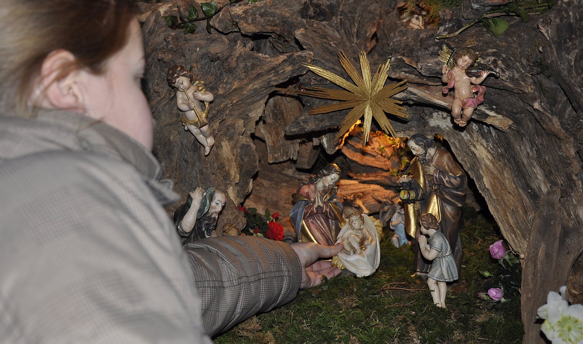 Das Bild zeigt ein Kind, das vor einer Krippe steht. 